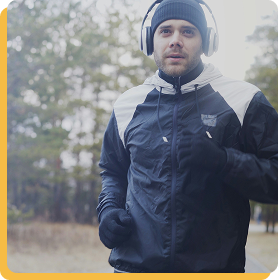 Image d’illustration : jogger courant en extérieur, posture dynamique et énergie visible, paysage urbain ou naturel en arrière-plan.